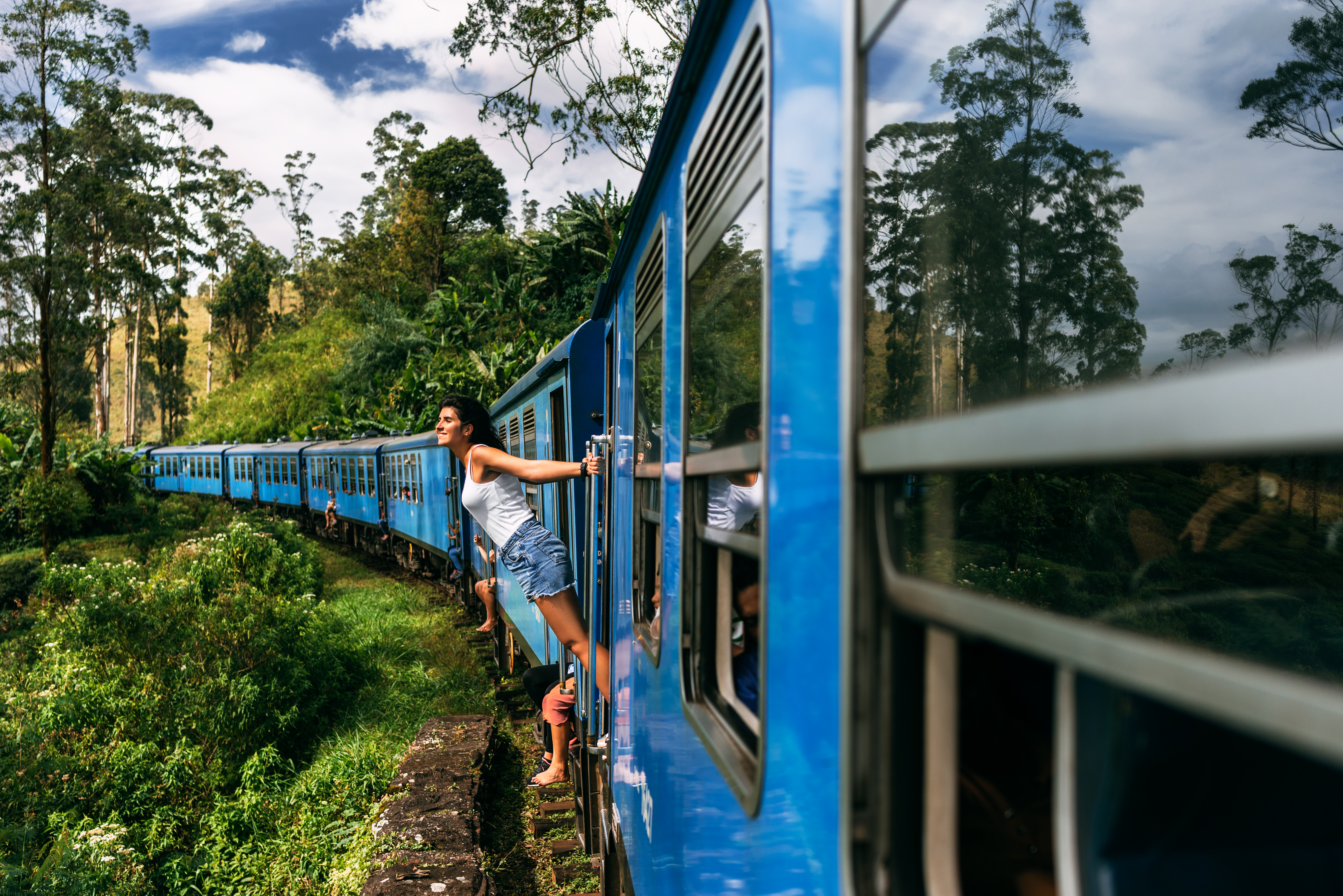 The girl travels by train to beautiful places. Beautiful girl traveling by train among mountains